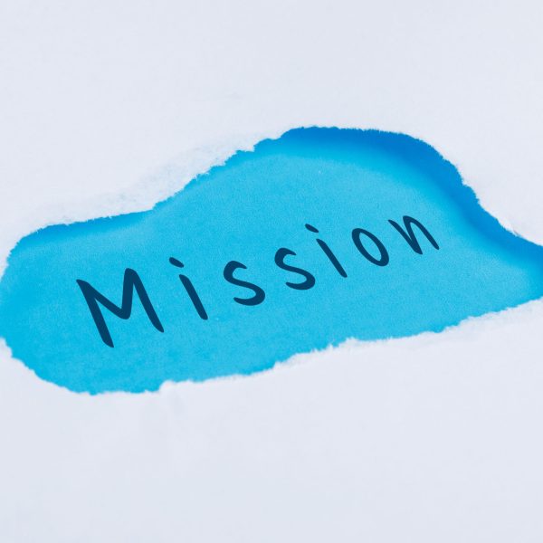 Marketing concept with mission word on blue and white background flat lay.